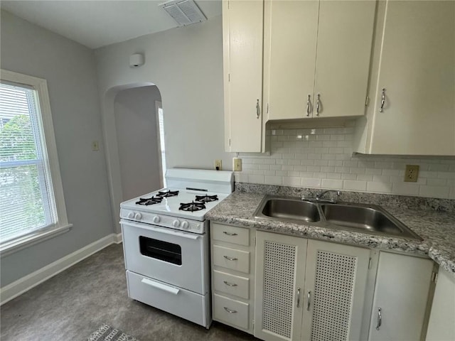 kitchen with white gas range, tasteful backsplash, and sink