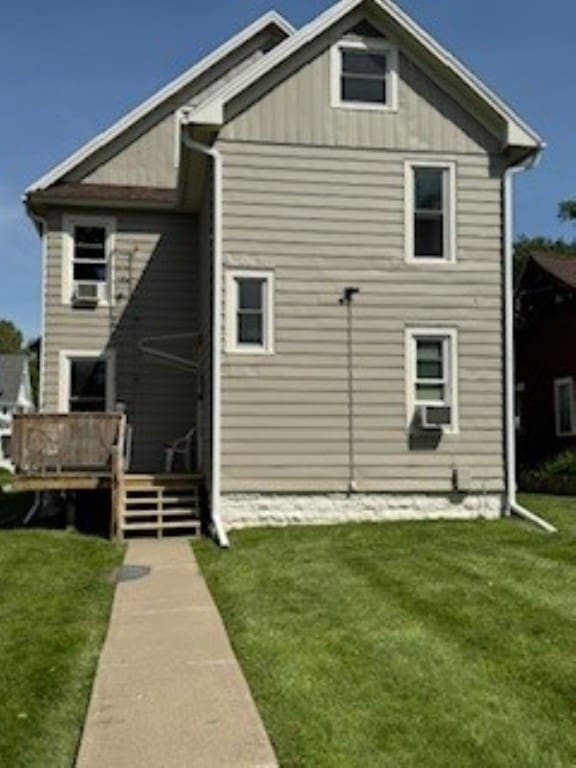 rear view of house featuring a yard, a deck, and cooling unit