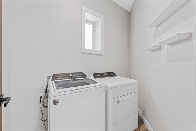 washroom with hardwood / wood-style flooring and washer and clothes dryer