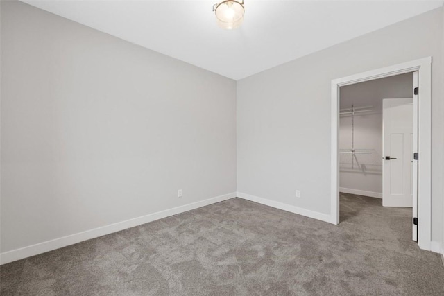 unfurnished bedroom featuring a walk in closet, carpet floors, and a closet