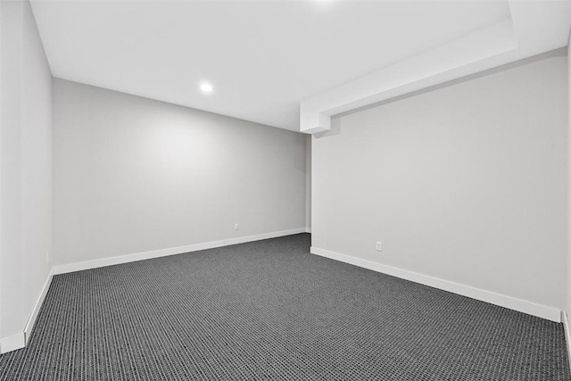 spare room with dark carpet