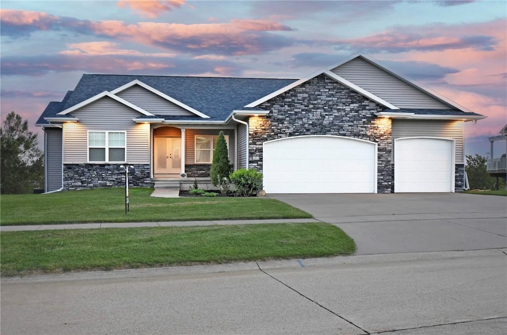 craftsman inspired home featuring a garage and a yard