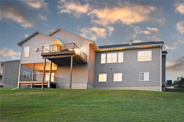 back house at dusk with a yard and a deck