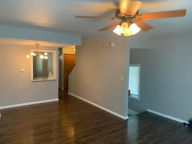 unfurnished room with dark hardwood / wood-style floors and ceiling fan with notable chandelier