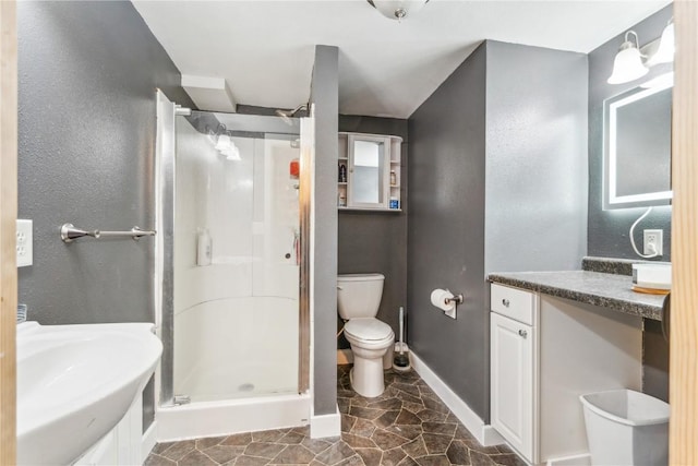 bathroom featuring vanity, toilet, and a shower with door