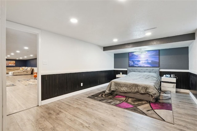 bedroom with hardwood / wood-style floors and wood walls