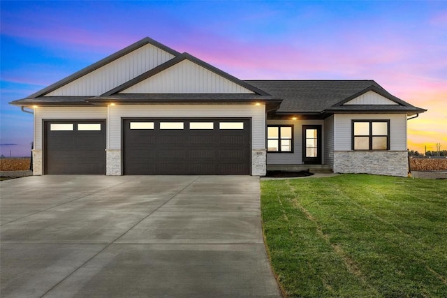 view of front of home with a garage and a lawn