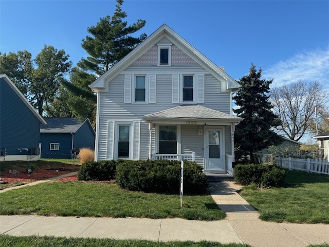 victorian-style house featuring covered porch and a front yard