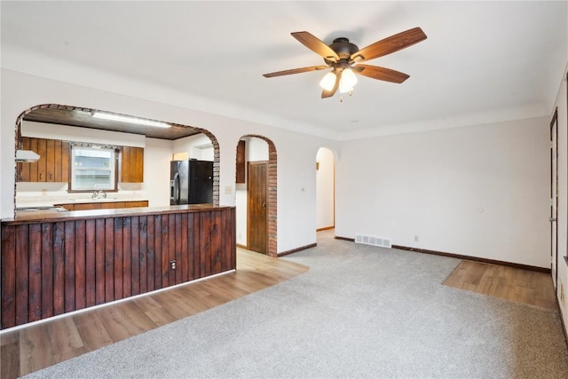 interior space with ceiling fan, light colored carpet, and sink