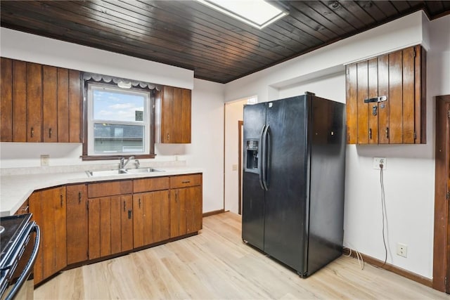 kitchen with electric stove, sink, black refrigerator with ice dispenser, and light hardwood / wood-style flooring