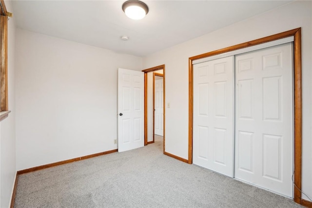 unfurnished bedroom with light carpet and a closet