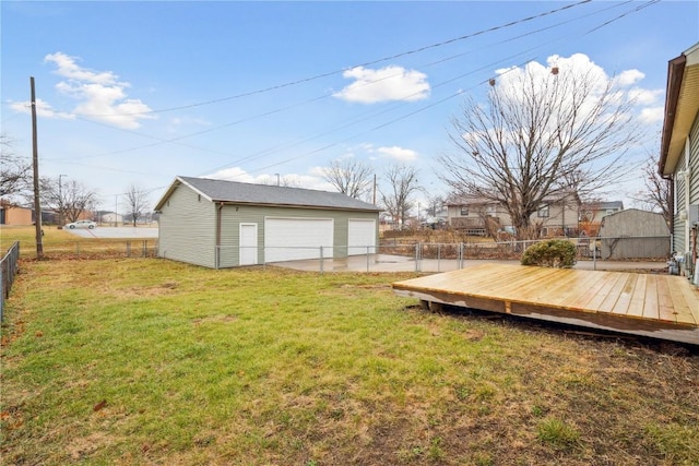 view of yard with an outbuilding, a deck, and a garage