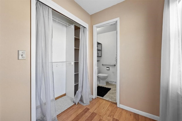 bathroom with wood-type flooring and toilet