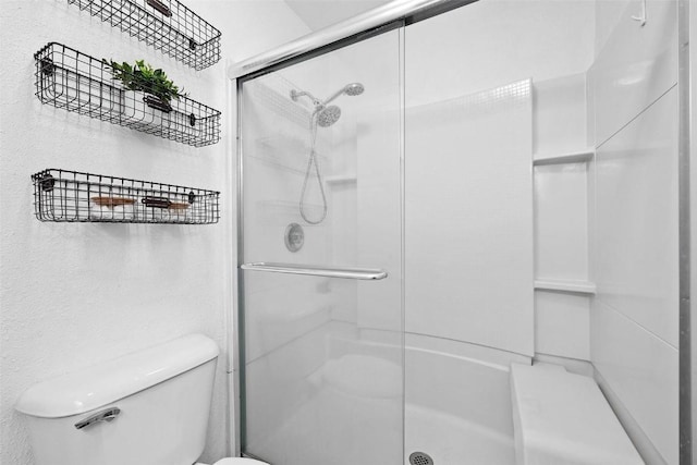 bathroom featuring toilet and walk in shower