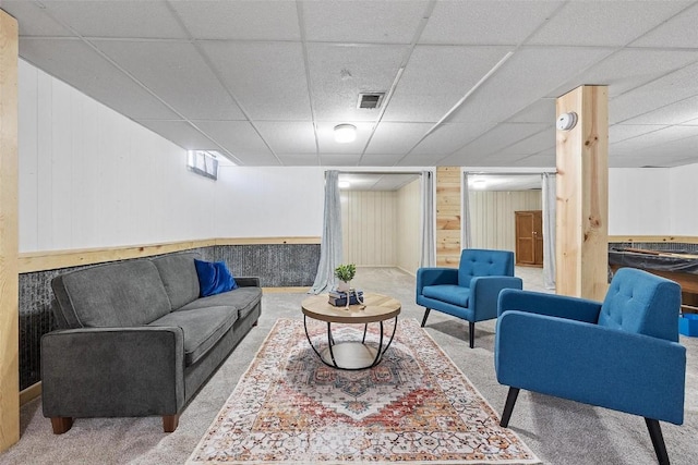 living room with carpet floors and wood walls