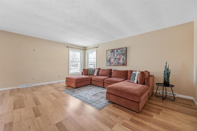 living room with light hardwood / wood-style flooring and a textured ceiling