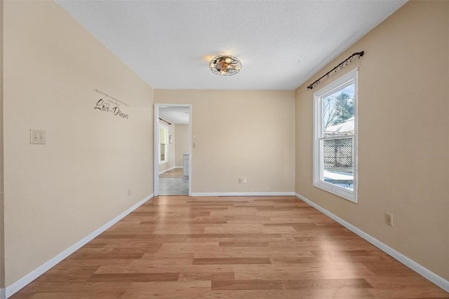 unfurnished room featuring a textured ceiling and light hardwood / wood-style floors