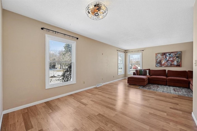 living room featuring light hardwood / wood-style floors and a textured ceiling