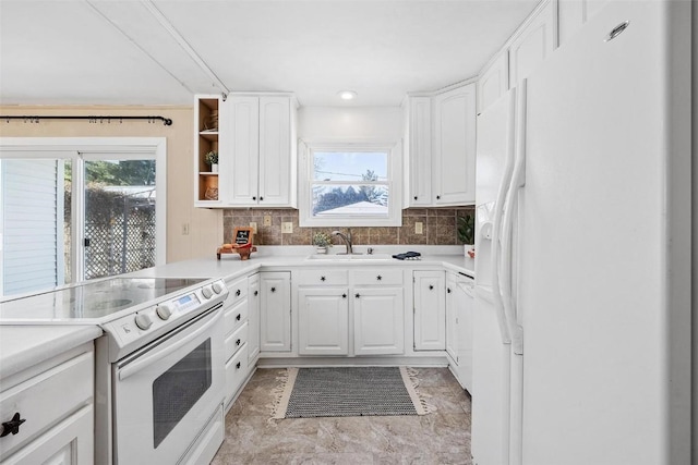 kitchen with white cabinets, white appliances, sink, and tasteful backsplash