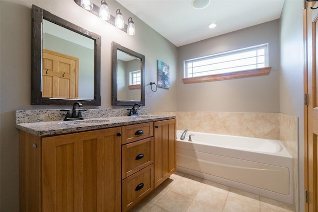 bathroom featuring tile patterned flooring, vanity, and a tub