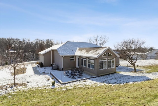 rear view of property featuring a lawn and central air condition unit