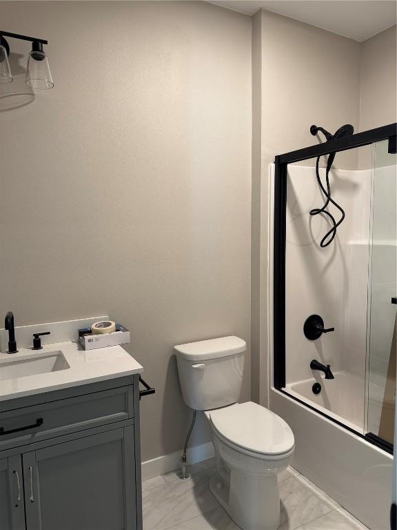 full bathroom featuring vanity, toilet, and shower / bath combination with glass door