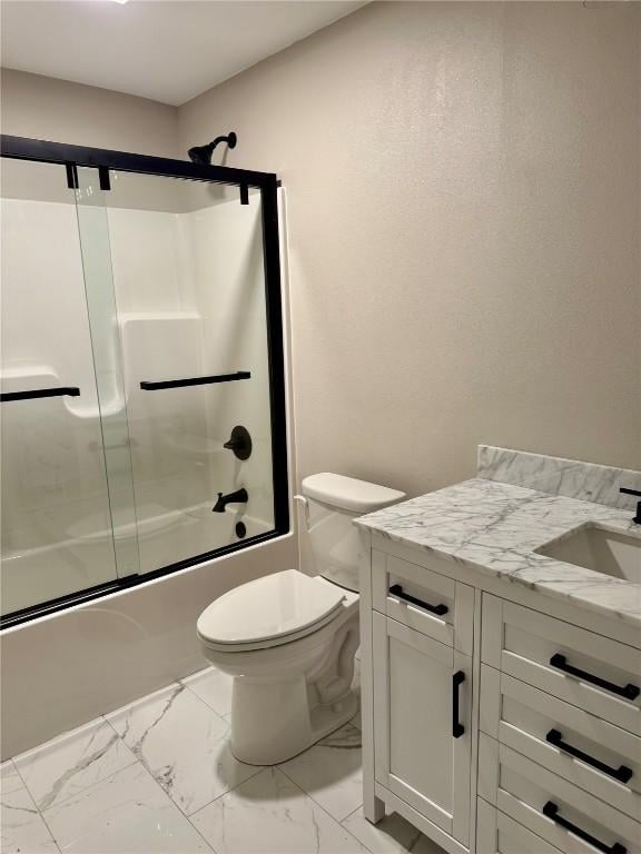 full bathroom with vanity, bath / shower combo with glass door, and toilet