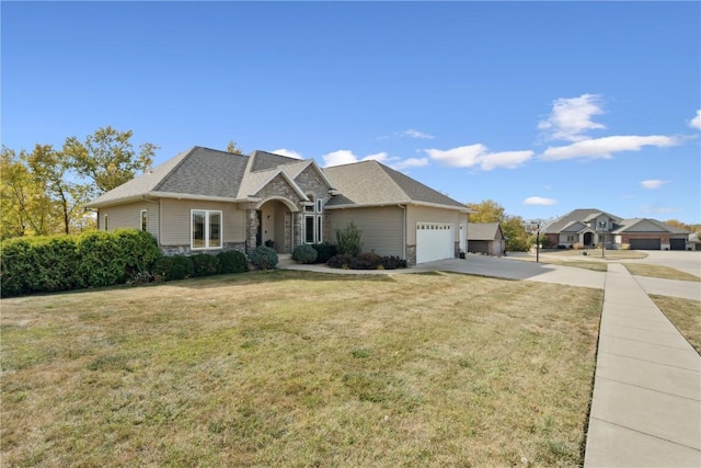 view of front of house with driveway, stone siding, roof with shingles, an attached garage, and a front yard