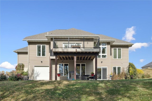 back of house with a deck, a shingled roof, a lawn, and an attached garage