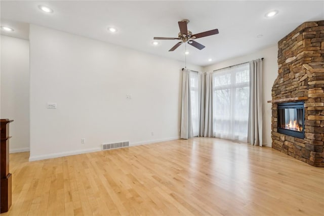 unfurnished living room featuring light wood finished floors, a fireplace, visible vents, and recessed lighting