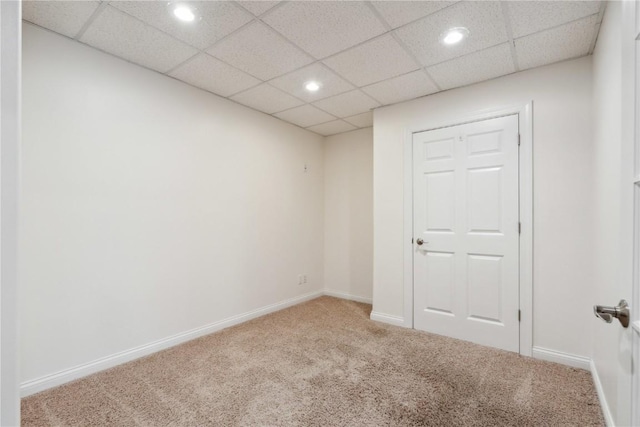 carpeted spare room with recessed lighting, a drop ceiling, and baseboards