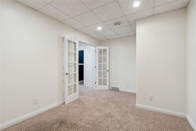 spare room with french doors, carpet, visible vents, and baseboards