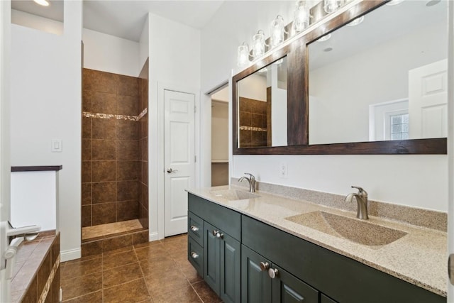 full bath featuring double vanity, tile patterned flooring, a walk in shower, and a sink