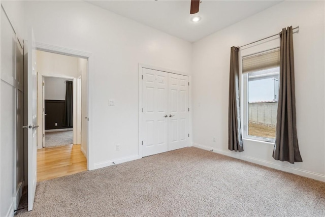 unfurnished bedroom featuring carpet floors, baseboards, and a closet