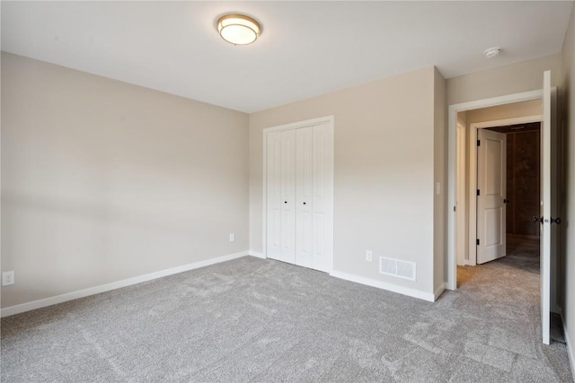 unfurnished bedroom with light carpet and a closet