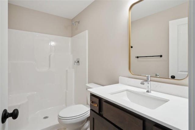 bathroom with a shower, vanity, and toilet