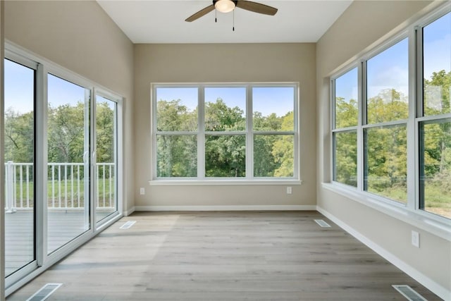 unfurnished sunroom featuring ceiling fan and a healthy amount of sunlight