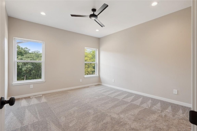 unfurnished room with light carpet, ceiling fan, and a healthy amount of sunlight