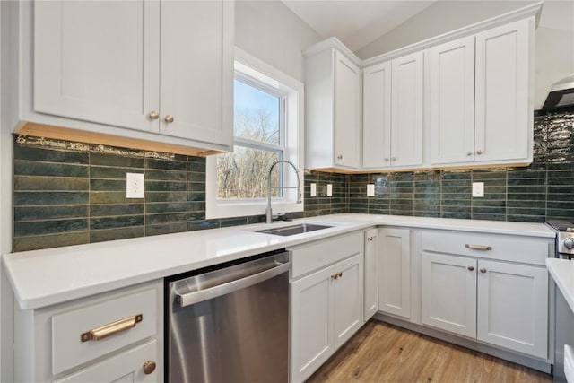 kitchen with light wood-type flooring, white cabinets, sink, dishwasher, and lofted ceiling