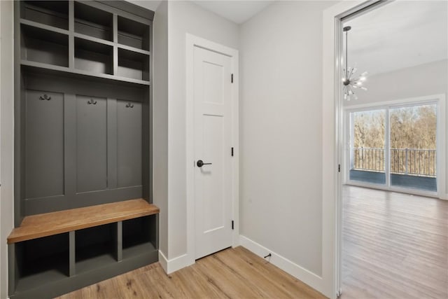 mudroom with a chandelier and light hardwood / wood-style floors