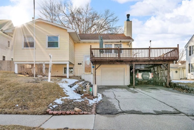 back of house featuring stairway, driveway, a chimney, and an attached garage