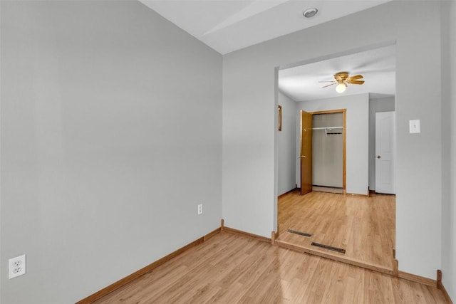 unfurnished room with light wood-type flooring, baseboards, and a ceiling fan