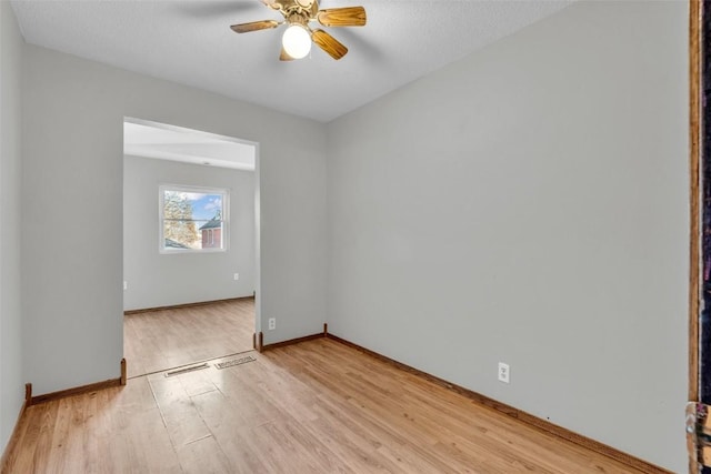 empty room with light wood-style floors, baseboards, and a ceiling fan