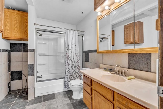 bathroom featuring shower / tub combo, toilet, a wainscoted wall, vanity, and tile walls