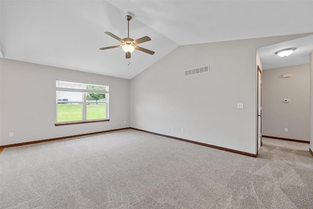 carpeted spare room with ceiling fan and vaulted ceiling