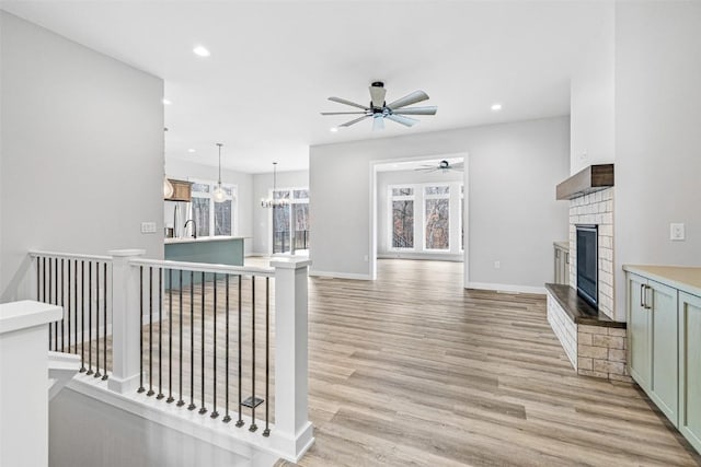 interior space featuring sink, light wood-type flooring, and a notable chandelier