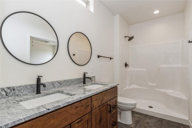 bathroom with tile patterned floors, vanity, toilet, and walk in shower