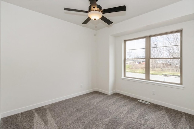 empty room with carpet floors, a wealth of natural light, and ceiling fan