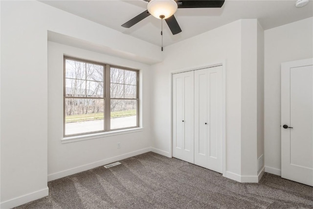 unfurnished bedroom featuring carpet floors, a closet, and ceiling fan