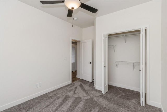 unfurnished bedroom with dark colored carpet, a closet, and ceiling fan